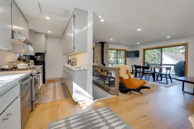 a kitchen with white cabinets and a dining room at Ski-InandSki-Out Retreat with Sauna in Bear Valley! in Bear Valley