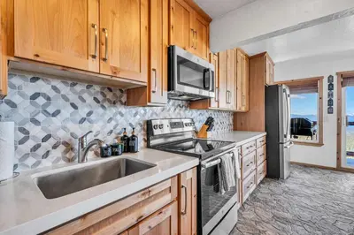 a kitchen with a sink and a refrigerator at Wooded Hilltop Stay Shared Hot Tub + Lake Views in Stateline