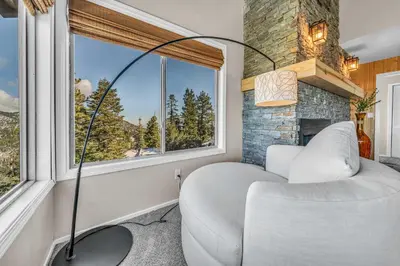 a bedroom with a bed and a chair and a window at Wooded Hilltop Stay Shared Hot Tub + Lake Views in Stateline