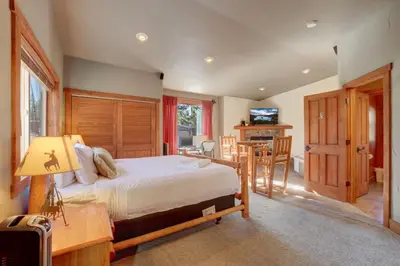 a bedroom with a bed and a table and chairs at Knotty by Nature 3 bed home in South Lake Tahoe