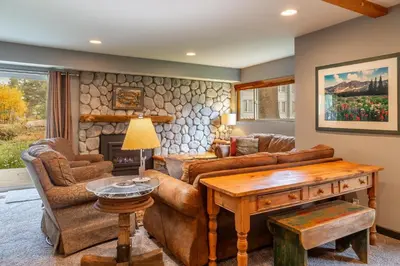 a living room with a couch and a table at Tranquil & Woodsy 2/2 Retreat – Jacuzzi, W/D, BBQ! in Mammoth Lakes
