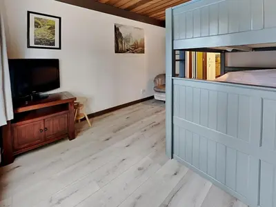 a room with a bedroom with a bed and a television at Slopeside Condo With Fireplace Snowbird 112 At 1849 Condos in Mammoth Lakes