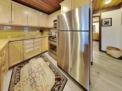 a stainless steel refrigerator in a kitchen with wooden cabinets at Slopeside Condo With Fireplace Snowbird 112 At 1849 Condos in Mammoth Lakes