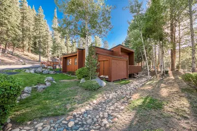 a cabin in the woods with a gravel road at Ridge Court # 13 by Tahoe Getaways - 3BR Palisades at Alpine Condo w Ski Shuttle & Tennis! in Alpine Meadows