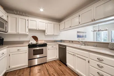 a kitchen with white cabinets and stainless steel appliances at Ridge Court # 13 by Tahoe Getaways - 3BR Palisades at Alpine Condo w Ski Shuttle & Tennis! in Alpine Meadows