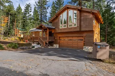 a log house with a garage and a driveway at North Shore - Forest Haven in Kings Beach