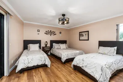a bedroom with two beds and a chandelier at Mountain Oasis-Indoor Hot Tub, Game Room, VIEWS in Oakhurst