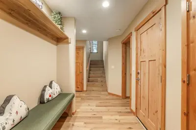 a hallway with a green bench and wooden floors at Woodlands House home in Truckee