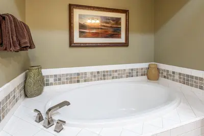 a white tub in a bathroom with a picture on the wall at Lodges 1178 - Timber Lodge Retreat in Mammoth Lakes