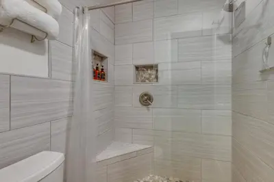 a white bathroom with a shower and a toilet at Mammoth Mtn Ski-InandOut Condo with Hot Tub Access! in Mammoth Lakes
