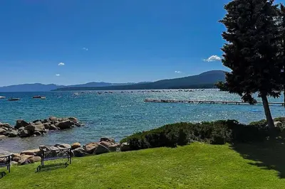a bench sitting on the grass near a body of water at Summit & Shore Chalet in Tahoe Vista