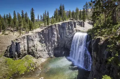 a waterfall on the side of a mountain with trees at Hidden Valley 29 D in Mammoth Lakes
