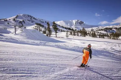 a man is skiing down a snow covered slope at Hidden Valley 29 D in Mammoth Lakes