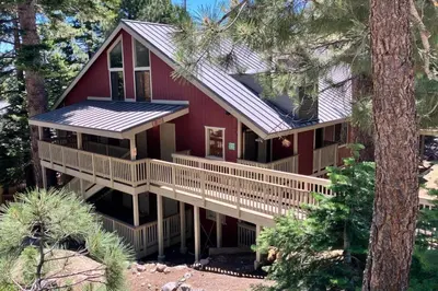 a red house with a deck in the woods at Hidden Valley 39 E in Mammoth Lakes