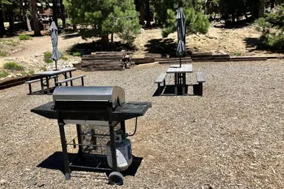 a bbq grill and two picnic tables with umbrellas at Hidden Valley 30 D in Mammoth Lakes