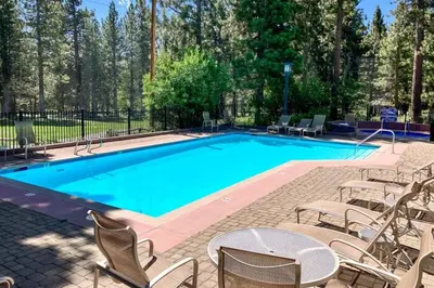 a large swimming pool with chairs and a table at Mammoth Green 219 in Mammoth Lakes