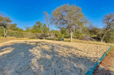 a volleyball court with a net on a sandy field at Scenic Yosemite Lakes Escape with Community Perks! in Coarsegold