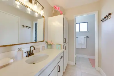 a white bathroom with a sink and a mirror at Scenic Yosemite Lakes Escape with Community Perks! in Coarsegold