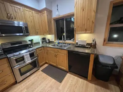 a kitchen with wooden cabinets and a stove top oven at Mountainside Family Chalet in Yosemite West