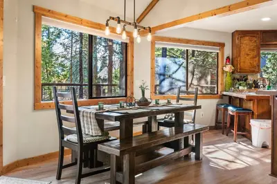 a dining room with a wooden table and chairs at Tranquil Treehouse near Fly-In Lake with Deck Dining & BBQ in Arnold