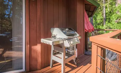 a grill on the porch of a house at Tranquil Treehouse near Fly-In Lake with Deck Dining & BBQ in Arnold