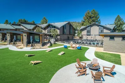 a yard with chairs and tables and a house at Outbound Mammoth in Mammoth Lakes