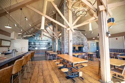 a restaurant with wooden tables and chairs and a bar at Outbound Mammoth in Mammoth Lakes