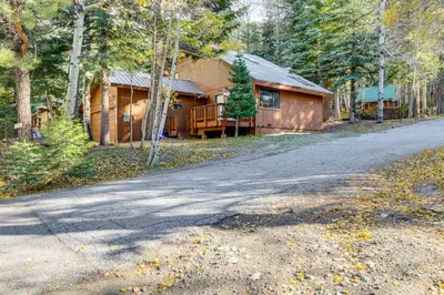 a house in the woods with a road in front of it at 1 Mi to Skiing! Cabin Hideaway on June Lake Loop in June Lake