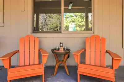 two orange chairs and a table with a bottle of beer at Stellars Jay Getaway Pet Friendly in City of SLT in South Lake Tahoe