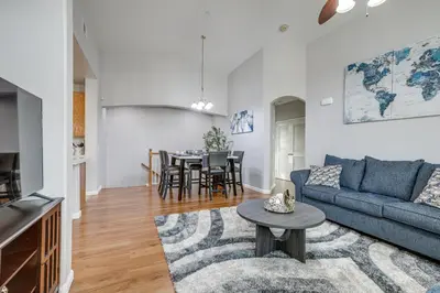 a living room with a blue couch and a table at Extended-Stay Ready! Elk Grove Unit with Pool Access in Elk Grove