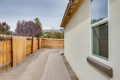 a fence with a window next to a house at Hike, Play and Unwind Charming Reno Unit in Reno