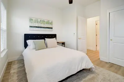 a white bedroom with a large bed with white sheets at Modern Cozy and contemporary in Ione