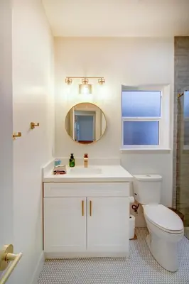 a white bathroom with a toilet and a mirror at Modern Cozy and contemporary in Ione