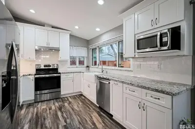 a kitchen with white cabinets and stainless steel appliances at Family 4BR Home with Patio by Willowcreek Park in Sparks