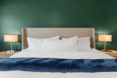 a large bed with white sheets and two lamps at Family 4BR Home with Patio by Willowcreek Park in Sparks