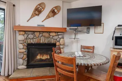 a living room with a fireplace and a table and a tv at (A108) Studio Condominiums in Yosemite West