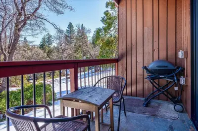 a screened in porch with a grill and chairs at (A111) Studio Condominiums in Yosemite West