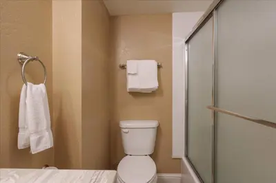 a bathroom with a toilet and a shower with towels at (A111) Studio Condominiums in Yosemite West