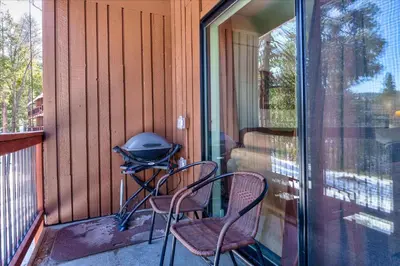 a screened porch with two chairs and a grill on it at (A109) Studio Condominiums in Yosemite West