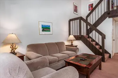 a living room with a couch and a staircase at (A202) Loft Condominiums in Yosemite West