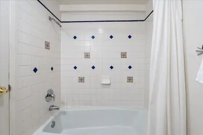 a white bath tub with a shower curtain in a bathroom at (A204) Loft Condominiums in Yosemite West