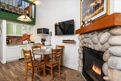 a kitchen with a table and chairs and a fireplace at (A204) Loft Condominiums in Yosemite West