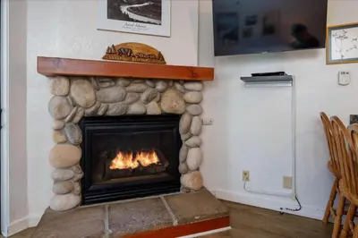 a fireplace in a living room with a fire at (A110) Studio Condominiums in Yosemite West