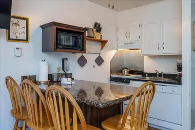 a kitchen with a counter with chairs and a microwave at (A110) Studio Condominiums in Yosemite West