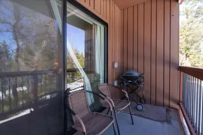 a screened in porch with two chairs and a grill at (A110) Studio Condominiums in Yosemite West