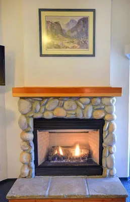 a stone fireplace with a fire in it at (A211) Loft Condominiums in Yosemite West