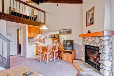 a living room with a fireplace and a table and chairs at (B211) Loft Condominiums in Yosemite West