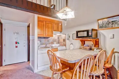 a kitchen with a table with chairs and a microwave at (B211) Loft Condominiums in Yosemite West