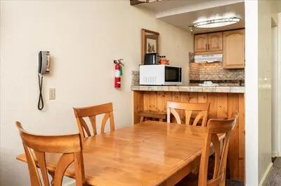 a kitchen and dining room with a wooden table and chairs at (B208) Loft Condominiums in Yosemite West