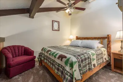 a bedroom with a bed and a chair at (B208) Loft Condominiums in Yosemite West